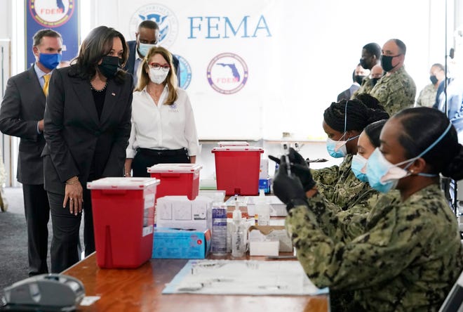 FEMA Regional Administrator Gracie Szczech, center, takes Vice President Kamala Harris on a tour of the Jacksonville Community Vaccination Center in Florida, where Navy members prepare Pfizer vaccines on March 22nd.