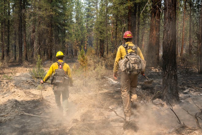 Firemen Garret Suza (right) and Cameron Taylor of the Chiloquin Forest Service are searching for hotspots near the Sprague River, Ore, on the northeast side of the Bootleg Fire on Wednesday, July 14, 2021.