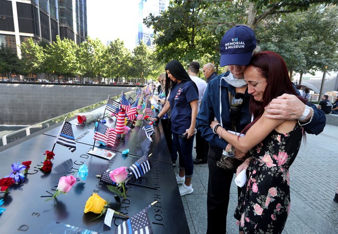 Mercedes Arias, formerly from Yonkers, NY, is comforted by a 9/11 Museum employee as she cries next to the name of her father Joseph Amatuccio at the 9/11 Memorial on September 11, 2021, on the 20th anniversary of the 9/11 attacks.  Her father, who worked in the World Trade Center, died in the attacks.